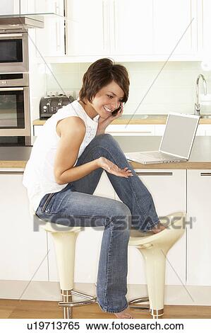 Young Woman Relaxing Sitting In Kitchen Talking On Phone View Large Photo Image Stock Photography - Young Woman Relaxing Sitting In Kitchen Talking On Phone. Fotosearch