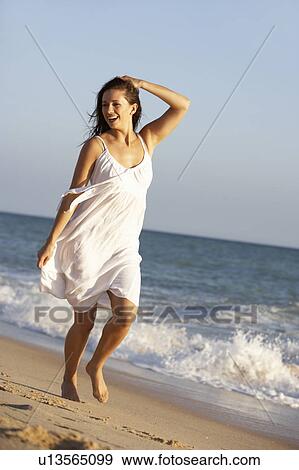 Stock Photo - Young Woman Running Along Summer Beach. Fotosearch