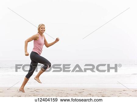 Young Woman Running Along Winter Beach View Large Photo Image Stock Photo - Young Woman Running Along Winter Beach. Fotosearch
