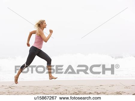 Stock Photo - Young Woman Running Along Winter Beach. Fotosearch