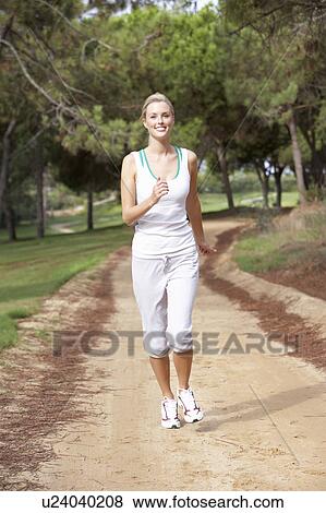 Young woman running in park View Large Photo Image Stock Photo - Young woman running in park. Fotosearch