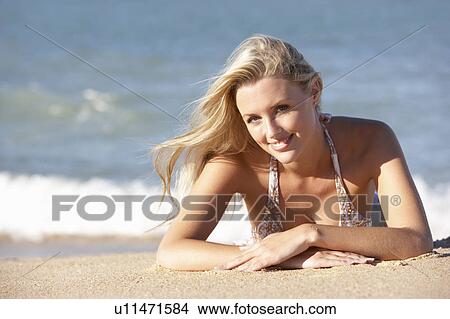 Picture - Young Woman Sunbathing On Beach . Fotosearch