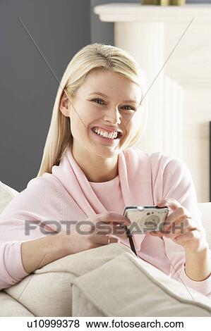 Stock Photo - Young Woman Taking Photograph On Digital Camera At Home . Fotosearch