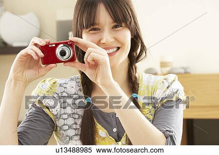 Young Woman Taking Photograph On Digital Camera At Home View Large Photo Image Stock Photography - Young Woman Taking Photograph On Digital Camera At Home . Fotosearch