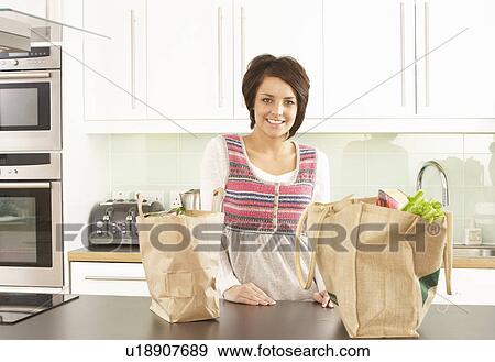 Young Woman Unpacking Shopping In Modern Kitchen View Large Photo Image Stock Photo - Young Woman Unpacking Shopping In Modern Kitchen. Fotosearch