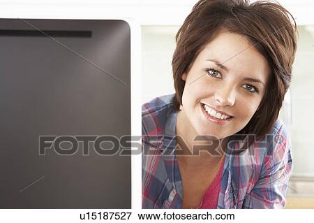 Young Woman Using Computer In Modern Kitchen View Large Photo Image Stock Photo - Young Woman Using Computer In Modern Kitchen . Fotosearch