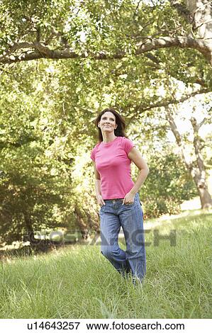 Young Woman Walking Through Long Grass In Park View Large Photo Image Stock Photo - Young Woman Walking Through Long Grass In Park. Fotosearch