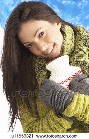 Young Woman Wearing Warm Winter Clothes Holding Hot Water Bottle In Studio View Large Photo Image Stock Image - Young Woman Wearing Warm Winter Clothes Holding Hot Water Bottle In Studio. Fotosearch