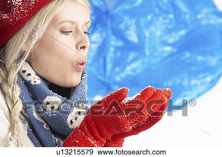 Young Woman Wearing Warm Winter Clothes And Hat Holding Snow In Studio View Large Photo Image Stock Photo - Young Woman Wearing Warm Winter Clothes And Hat Holding Snow In Studio. Fotosearch