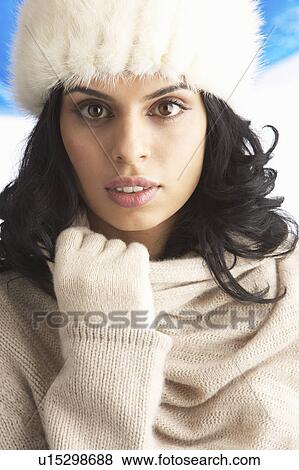 Stock Photo - Young Woman Wearing Warm Winter Clothes And Fur Hat In Studio. Fotosearch