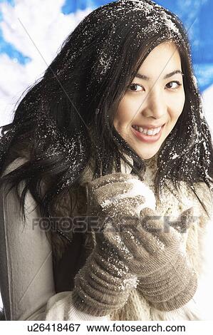 Stock Photo - Young Woman Wearing Warm Winter Clothes Holding Snowball In Studio. Fotosearch