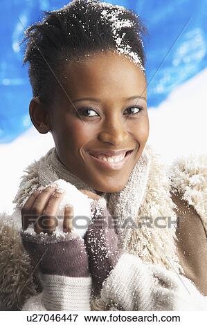 Stock Photo - Young Woman Wearing Warm Winter Clothes Holding Snowball In Studio. Fotosearch
