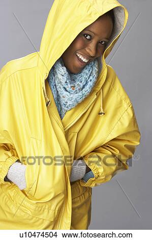 Picture - Young Woman Wearing Yellow Raincoat In Studio. Fotosearch