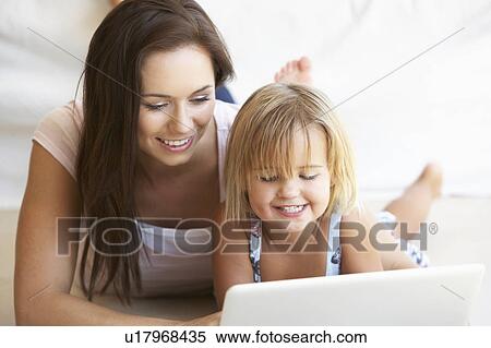 Young woman with girl using laptop computer View Large Photo Image Stock Photography - Young woman with girl using laptop computer. Fotosearch