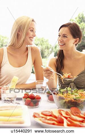 Young women eating outdoors View Large Photo Image Stock Image - Young women eating outdoors. Fotosearch