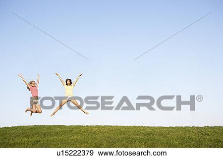 Young women jumping in air View Large Photo Image Stock Photo - Young women jumping in air. Fotosearch