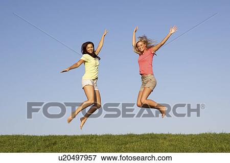 Young women jumping in air View Large Photo Image Stock Photo - Young women jumping in air. Fotosearch