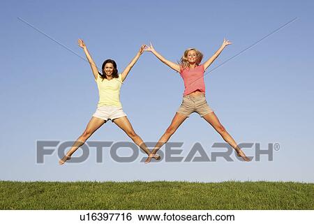 Young women jumping in air View Large Photo Image Stock Photograph - Young women jumping in air. Fotosearch