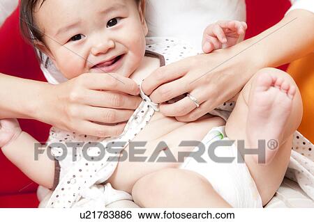 Stock Photograph - Baby Boy Being Dressed. Fotosearch