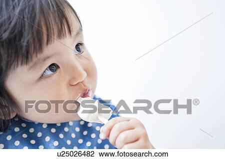 Stock Image - Baby boy eating ice cream. Fotosearch