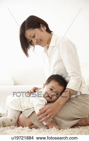 Picture - Baby Boy Lying on Mother's Lap. Fotosearch