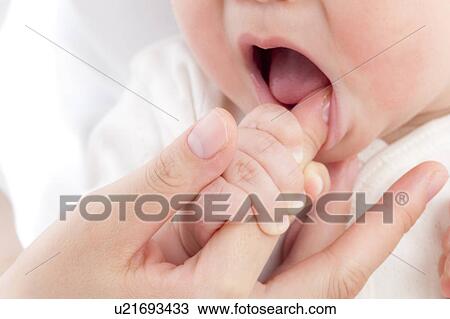 Stock Image - Baby Sucking Mother's Finger. Fotosearch