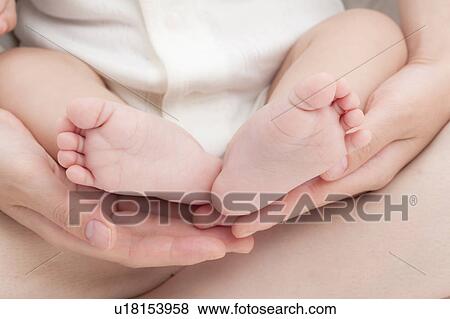 Stock Photo - Baby's Feet on Mother's Hands. Fotosearch