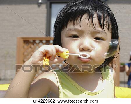 Stock Image - Boy blowing bubble, Chiba Prefecture, Honshu, Japan. Fotosearch
