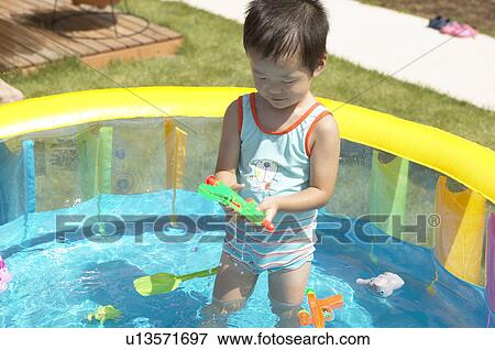 Boy holding water gun in wading pool, Chiba Prefecture, Honshu, Japan View Large Photo Image Stock Photo - Boy holding water gun in wading pool, Chiba Prefecture, Honshu, Japan. Fotosearch