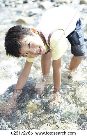 Stock Photography - Boy Playing in River. Fotosearch