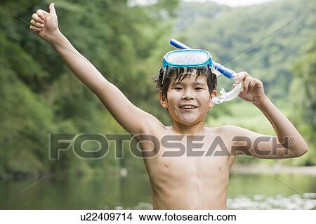 Picture - Boy standing in river wearing snorkel, Chiba Prefecture, Honshu, Japan. Fotosearch