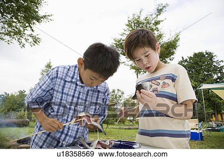 Boys skewering fishes, Chiba Prefecture, Honshu, Japan View Large Photo Image Stock Photo - Boys skewering fishes, Chiba Prefecture, Honshu, Japan. Fotosearch
