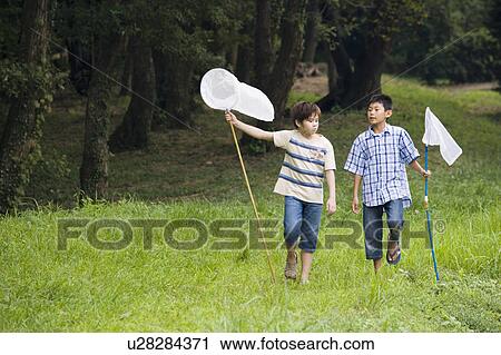 Stock Image - Boys walking with butterfly nets, Chiba Prefecture, Honshu, Japan. Fotosearch