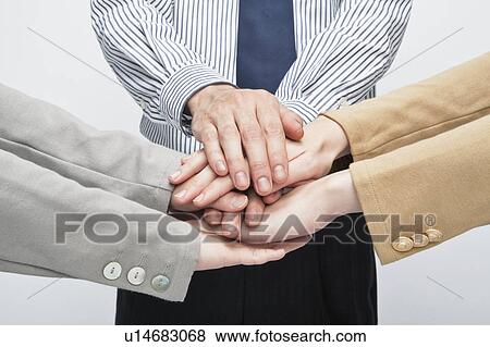 Stock Photo - Business people stacking hands. Fotosearch
