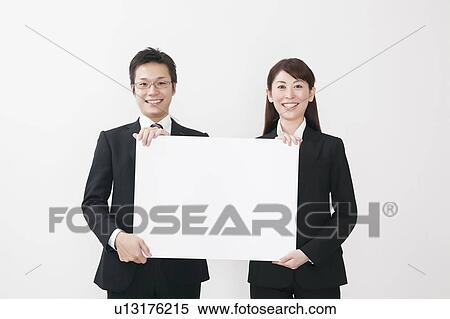 Stock Photography - Businessman and businesswoman holding blank cardboard. Fotosearch