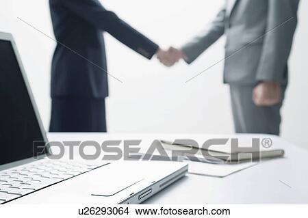 Picture - Businessman and businesswoman shaking hands. Fotosearch