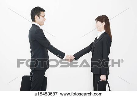 Stock Photo - Businessman and businesswoman shaking hands. Fotosearch