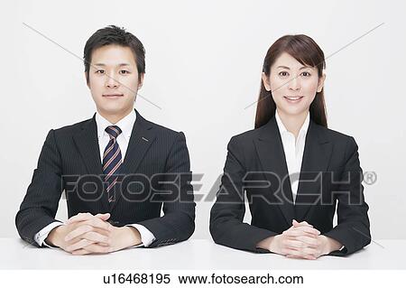 Stock Photography - Businessman and businesswoman sitting side by side. Fotosearch