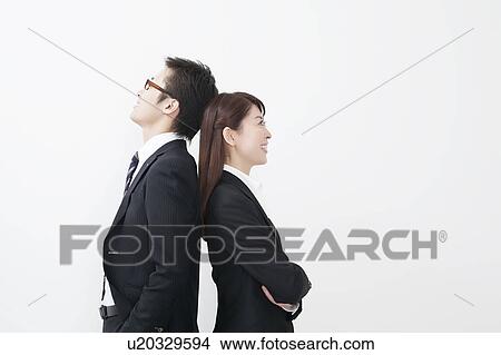 Picture - Businessman and businesswoman standing back to back. Fotosearch