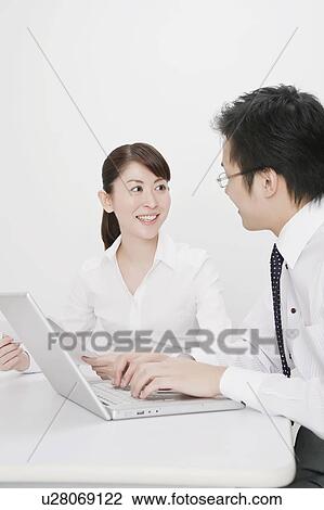 Stock Image - Businessman and businesswoman talking. Fotosearch