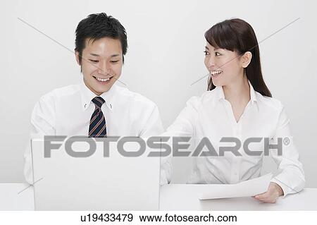 Stock Photo - Businessman and businesswoman working together. Fotosearch