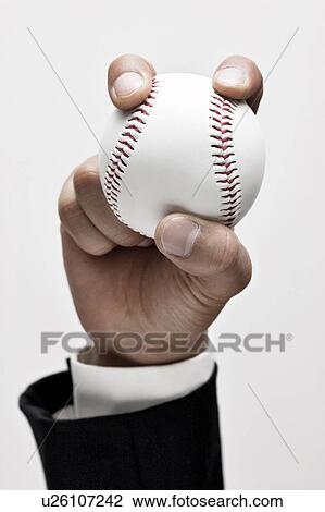 Stock Image - Businessman holding a baseball. Fotosearch