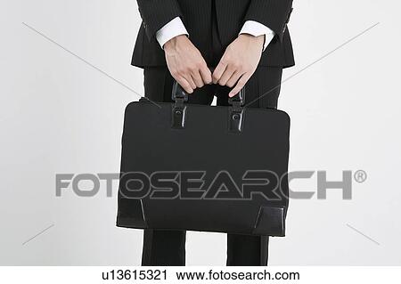 Stock Image - Businessman holding a briefcase. Fotosearch