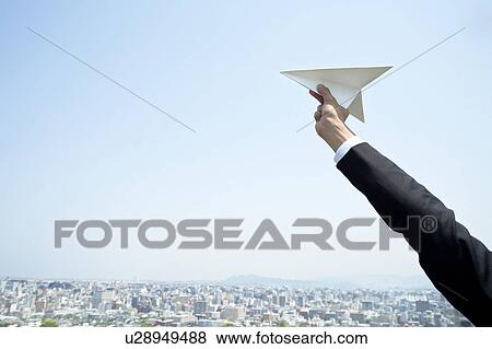 Businessman holding a paper plane and cityscape View Large Photo Image Stock Photo - Businessman holding a paper plane and cityscape. Fotosearch
