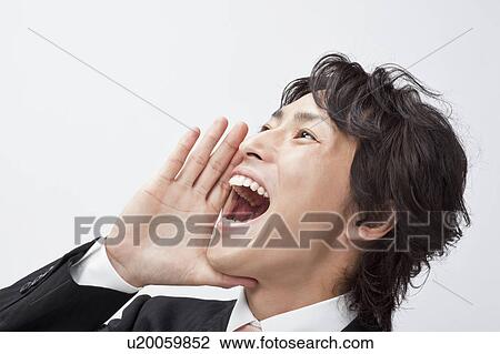 Stock Image - Businessman shouting with hands covering mouth. Fotosearch