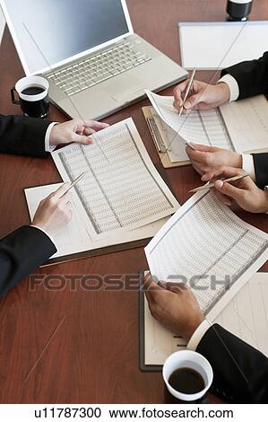 Stock Image - Businessmen and businesswoman having a meeting. Fotosearch