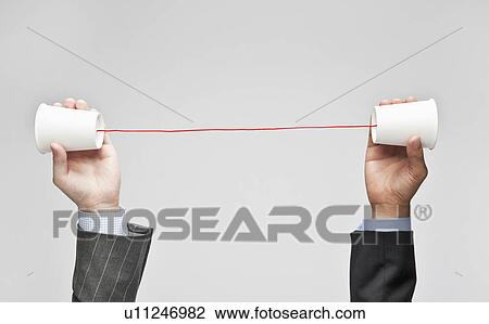 Businessmen holding tin can phone View Large Photo Image Stock Image - Businessmen holding tin can phone. Fotosearch