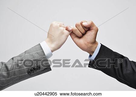 Stock Photography - Businessmen pinky swearing. Fotosearch