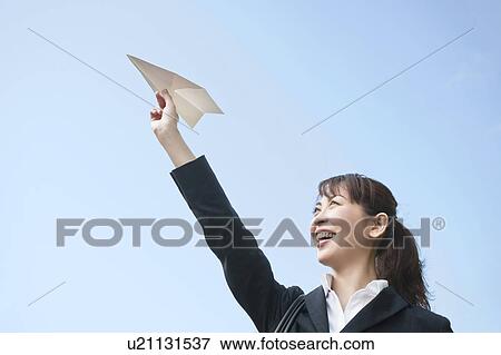Stock Photo - Businesswoman holding a paper plane. Fotosearch