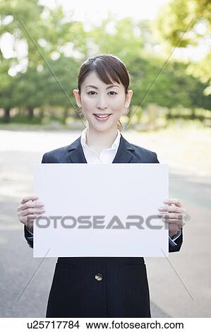 Picture - Businesswoman holding blank cardboard. Fotosearch